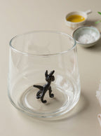 Trinkglas mit schwarzem Hund im Glas
