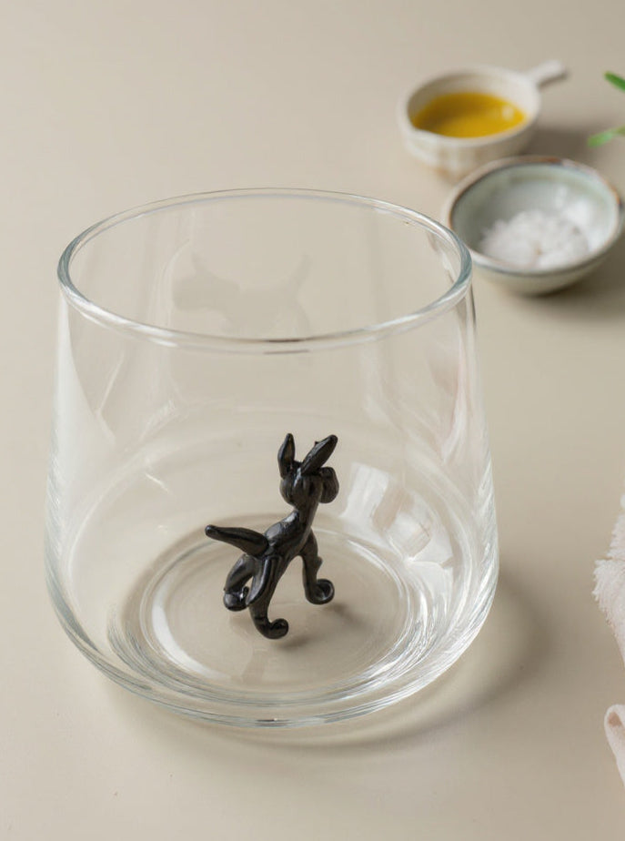 Trinkglas mit schwarzem Hund im Glas