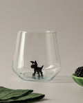 Trinkglas mit schwarzem Hund im Glas
