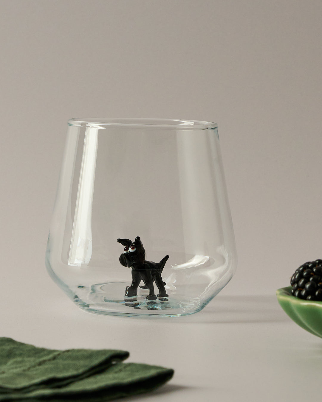 Trinkglas mit schwarzem Hund im Glas