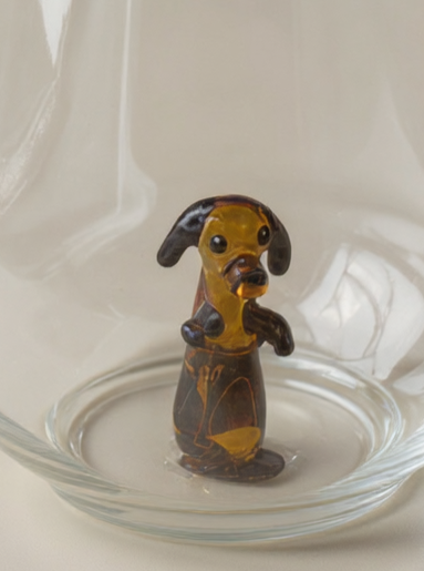 Trinkglas mit schwarzem Hund im Glas