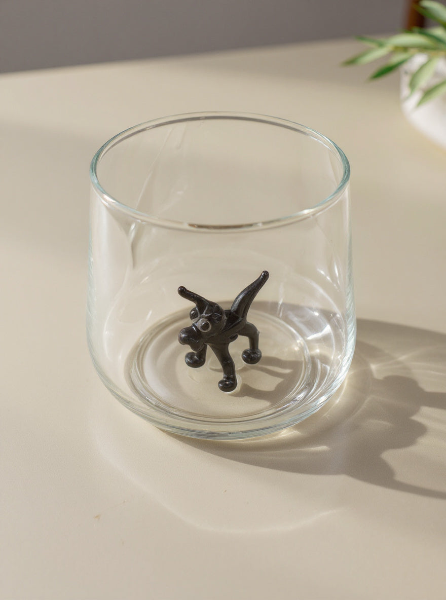 Trinkglas mit schwarzem Hund im Glas