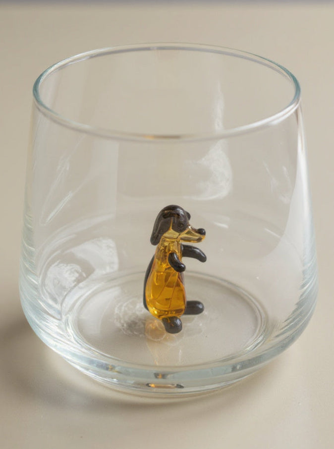 Trinkglas mit schwarzem Hund im Glas